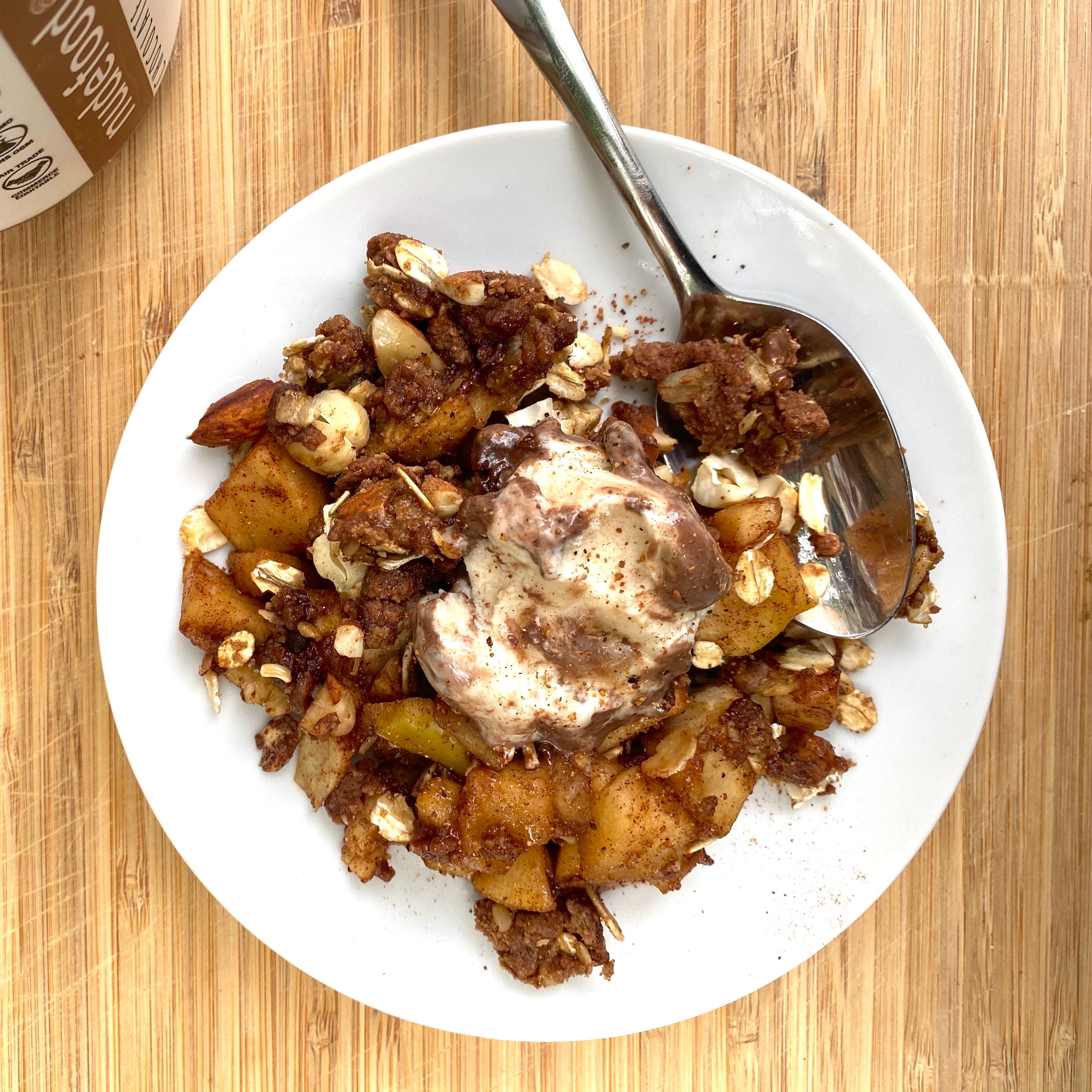 Baked apple crisp on a plate with a chocolate peanut butter oat crumble 